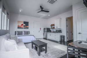 Living area with visible vents, a ceiling fan, and recessed lighting