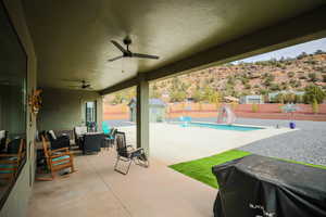 View of patio / terrace with a fenced in pool, a storage unit, outdoor lounge area, a ceiling fan, and an outdoor structure