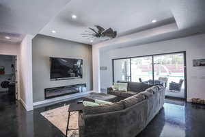 Living area featuring finished concrete flooring, recessed lighting, visible vents, washer / dryer, and baseboards