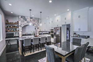 Dining space featuring baseboards, concrete floors, and recessed lighting