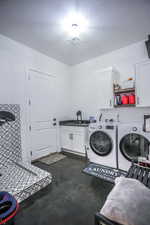 Laundry room with cabinet space, a sink, visible vents, and washing machine and clothes dryer