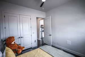 Bedroom featuring ceiling fan, baseboards, and a closet