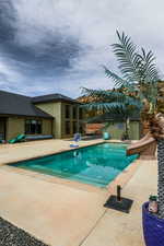 Outdoor pool with a patio and a water slide