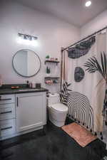 Bathroom featuring recessed lighting, a shower with curtain, vanity, and toilet