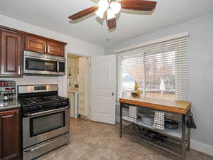 Kitchen with a ceiling fan and view to laundry