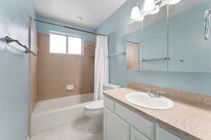 Full bathroom featuring shower / tub combo, tile patterned flooring, vanity, and toilet