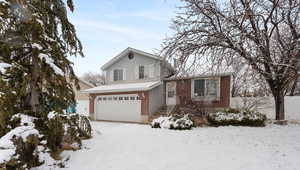 Tri-level home featuring brick, siding and an attached garage