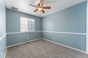 Room featuring carpet floors, baseboards, visible vents, and a ceiling fan