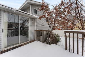 Snow covered deck, sliding glass doors, with fully  fenced yard.