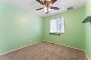 Room featuring a ceiling fan, carpet flooring, visible vents, and baseboards