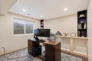 Office space featuring recessed lighting, visible vents, baseboards, and wood finished floors