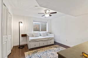 Bedroom featuring visible vents, dark wood finished floors, a ceiling fan, and baseboards