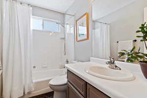 Full bath featuring toilet, shower / bathtub combination with curtain, and vanity