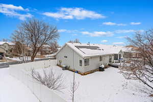 Snow covered back of property with fence