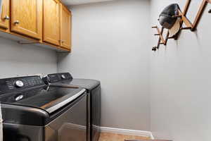 Laundry room featuring cabinet space, washing machine and dryer, and baseboards