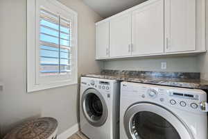 Laundry room featuring cabinets and washer and clothes dryer