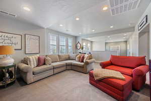 Carpeted living room featuring a textured ceiling