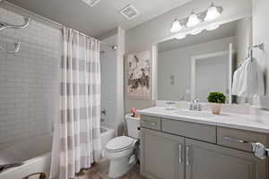 Full bathroom with vanity, tile patterned flooring, toilet, and shower / bath combo