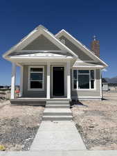 View of front of property featuring covered porch and a chimney