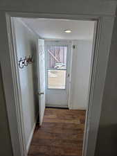 Doorway with dark hardwood / wood-style floors