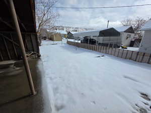 Snowy yard featuring a carport