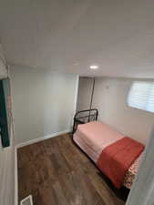 Bedroom featuring wood finished floors, visible vents, and baseboards