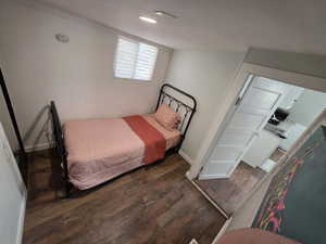 Bedroom with dark wood finished floors and baseboards