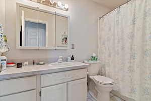 Bathroom with tile patterned flooring, a shower with curtain, vanity, and toilet