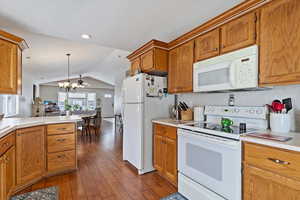 Kitchen with lots of cabinetry, white appliances, light countertops