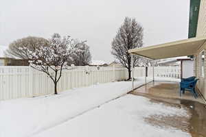 Partially fenced yard with a covered patio