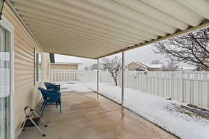 Covered patio with a partially fenced backyard