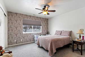 Bedroom with ceiling fan, carpet flooring, and a closet