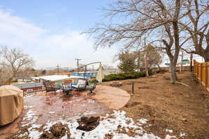 Large Side: Backyard featuring a fire pit, a patio area, and fence