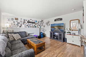 Smaller Side: Living area with fireplace and wood-type flooring