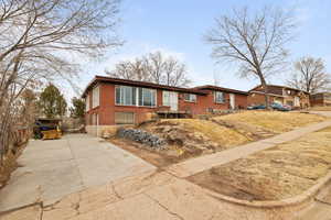 View of front of house with concrete driveway and brick siding