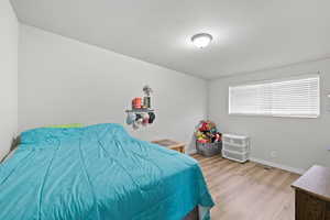 Smaller Side: Bedroom 2 featuring light wood-style floors and baseboards