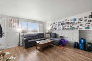 Smaller Side: Living area featuring baseboards and wood-type flooring