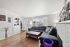 Smaller Side: Living area featuring baseboards and wood-type flooring