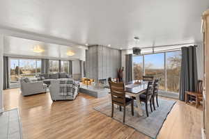 Large side: Dining room with light wood-type flooring and a brick fireplace