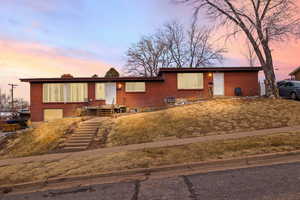 View of front of home with brick siding and a chimney