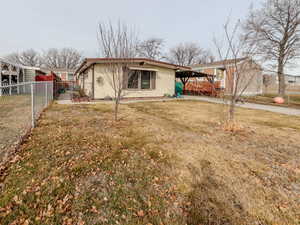 View of front of home with fence and a front lawn