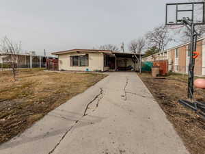 View of front of house with driveway, a front yard, and fence