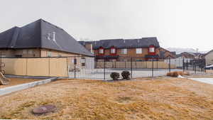 Exterior space featuring stucco siding, a fenced backyard, a residential view, and a yard