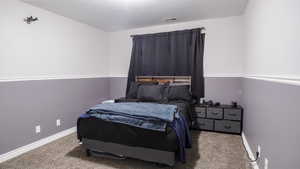 Bedroom with carpet, visible vents, and baseboards