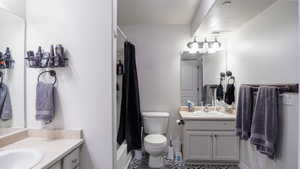 Bathroom featuring visible vents, two vanities, a sink, and toilet