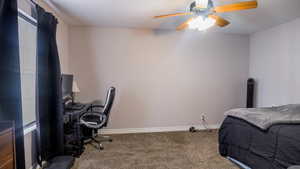 Carpeted bedroom featuring a ceiling fan and baseboards