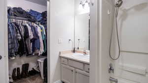 Full bath with a spacious closet, shower / washtub combination, and vanity