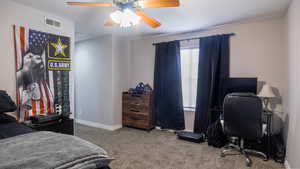 Carpeted bedroom with a ceiling fan, visible vents, and baseboards