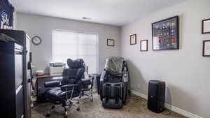 Office space featuring carpet flooring, visible vents, and baseboards