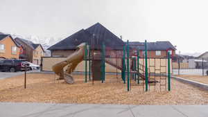 Community jungle gym with fence and a residential view